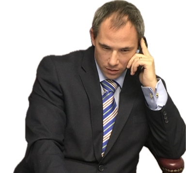 Ontario Wills Lawyer David Chaten sitting at a desk creating wills wearing a suit and tie. He has short black hair.