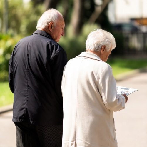 Ontario will and estate planning- older couple walking together happy with their Ontario lawyer made Will package, woman wearing white coat, man wearing black coat