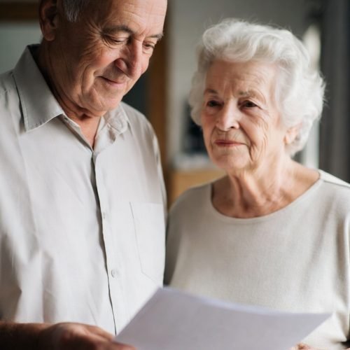 Ontario Power of Attorney for Personal Care- Elderly couple standing together in white shirts holding their poa documents